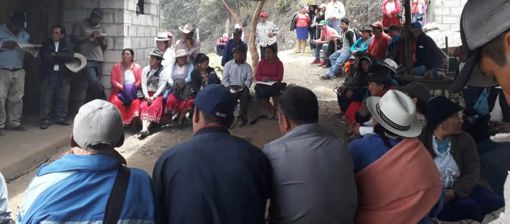 View of a gathering of local people outside simple buildings