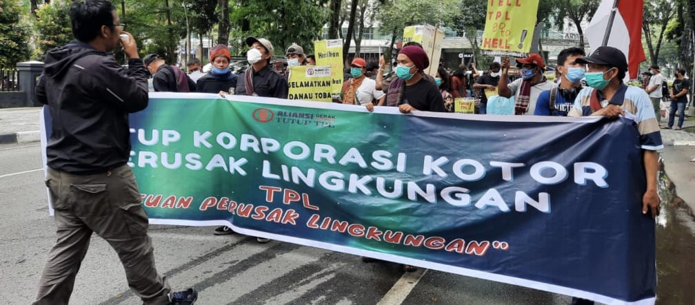 Photographer and protesters with a green banner