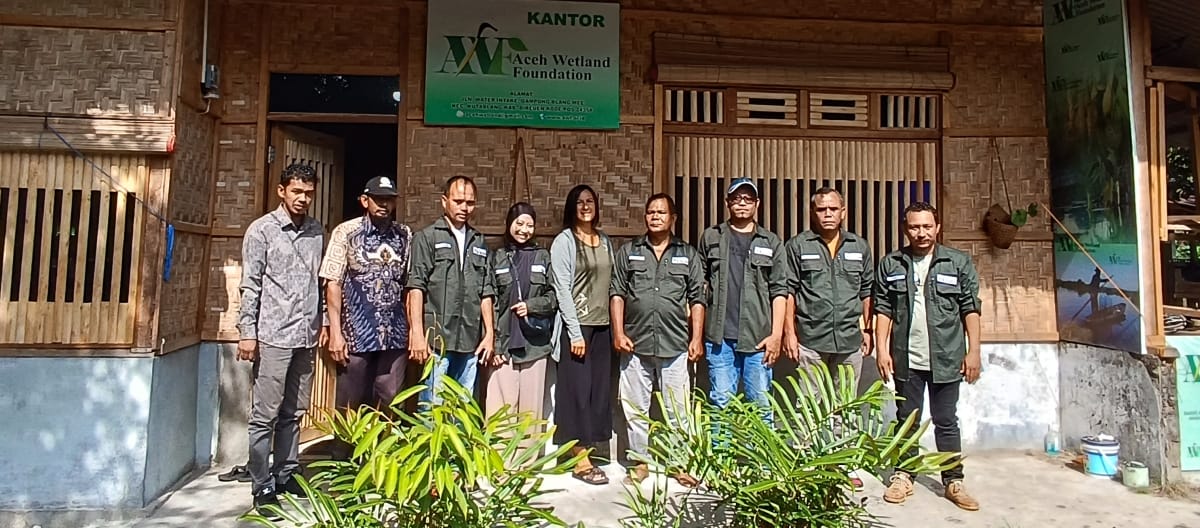 Group photo of the AWF team in front of the office building made of rattan and bamboo