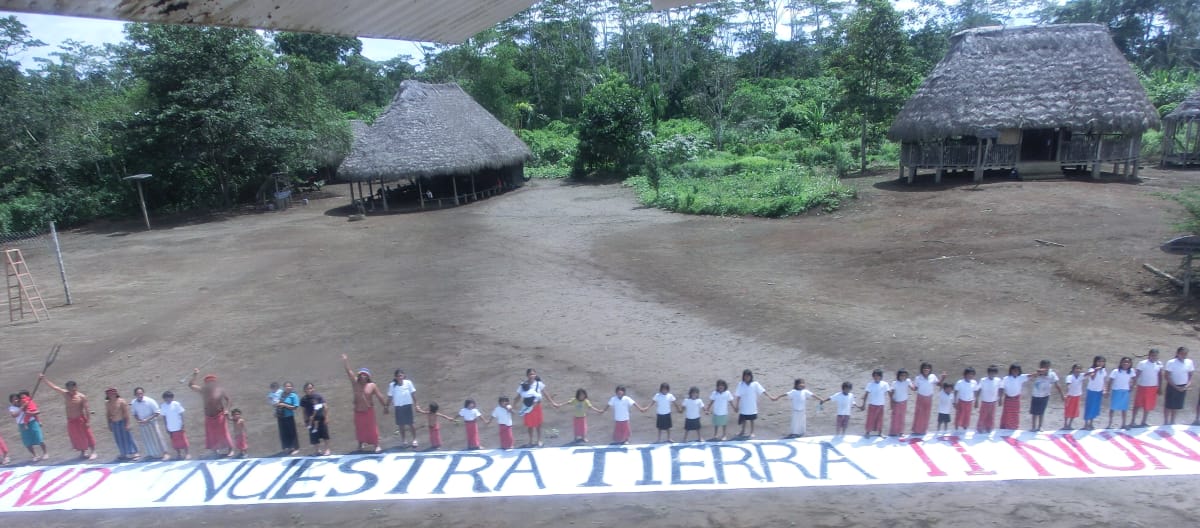 Our land – nuestra tierra! Human chain with banner against land grabbing in Ecuador