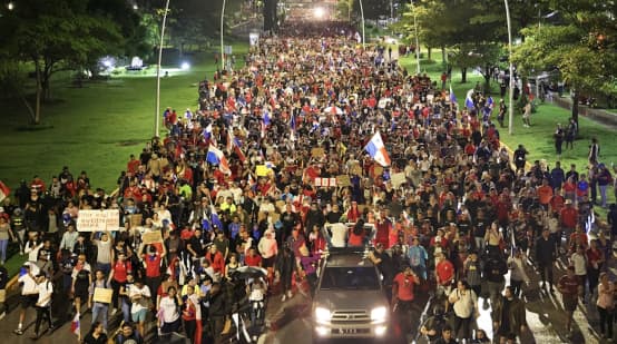 A protest march with thousands of people fills a street in the capital