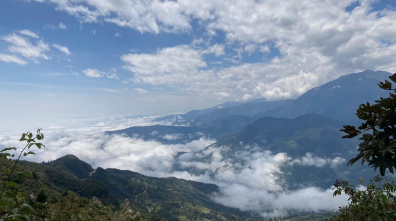 Mountain landscape with white clouds hugging the ground and above in the sky