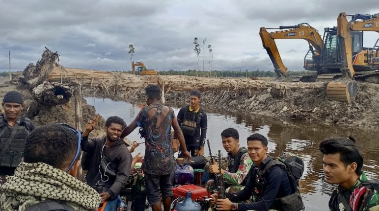 Excavators behind a group of men