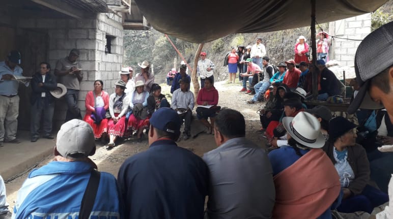 View of a gathering of local people outside simple buildings