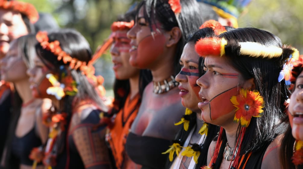 Young Indigenous women adorned with feathers
