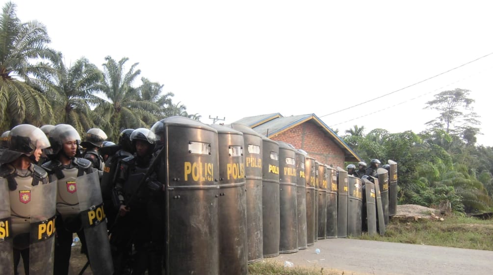 What is the greater threat to a peaceful society – indigenous people or the palm oil industry? Indonesia: police securing oil palm plantation