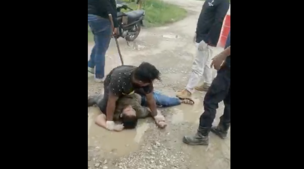 A villager is assaulted by plantation workers