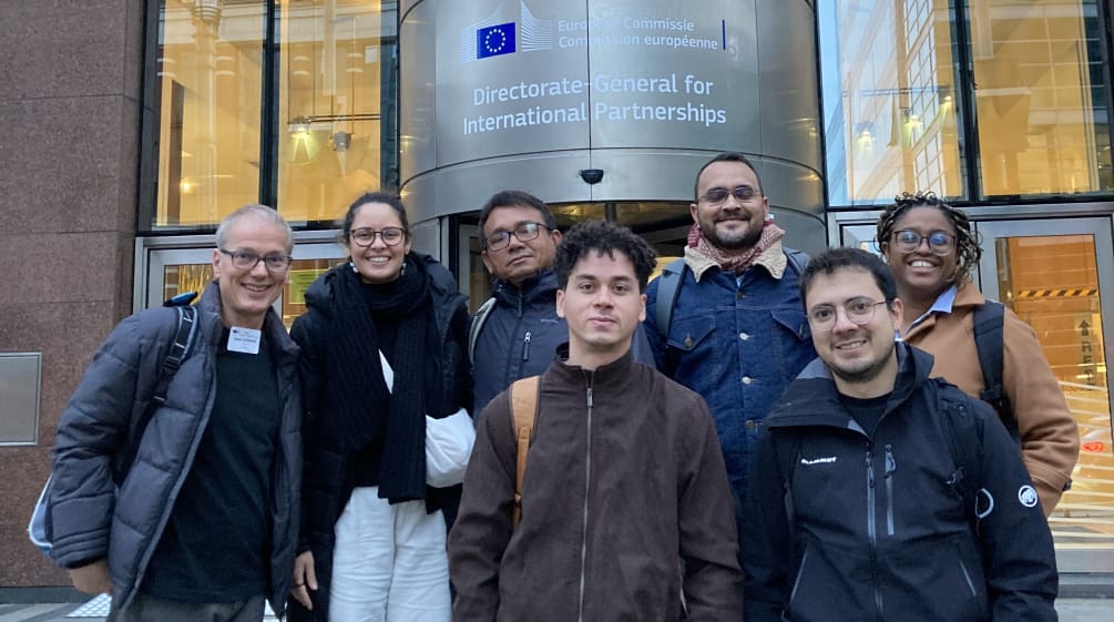 Group photo of seven people in front of the entrance of a building of the EU Commission in Brussels