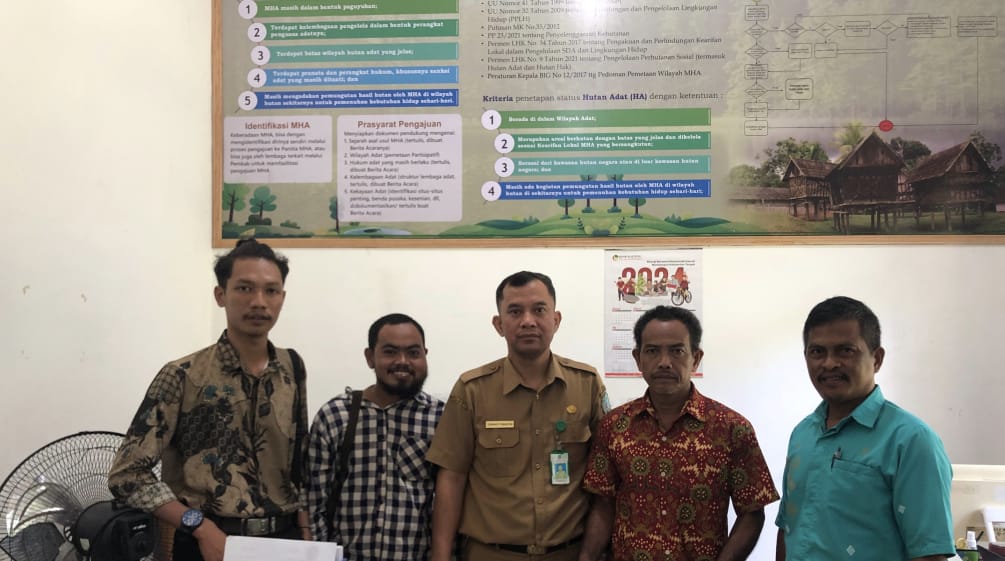 Five men pose in the office of a government agency