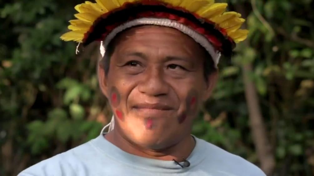 Portrait of indigenous leader Sarapo Ka'apor wearing a feather headdress
