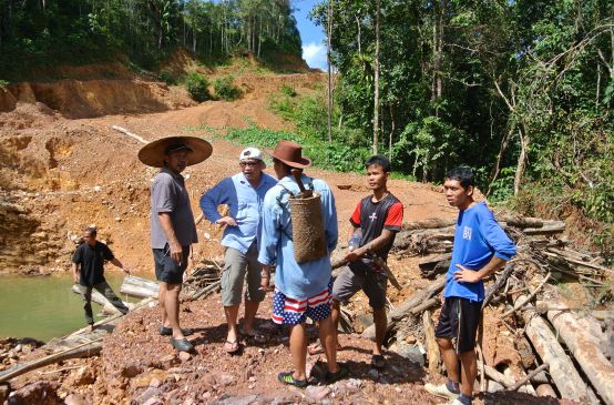 Matek (SADIA) with indigenous people at an illegal logging site