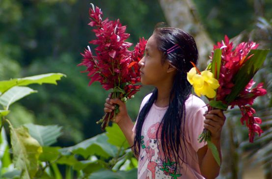 Kichwa girl with flowers in her hand in Sarayaku