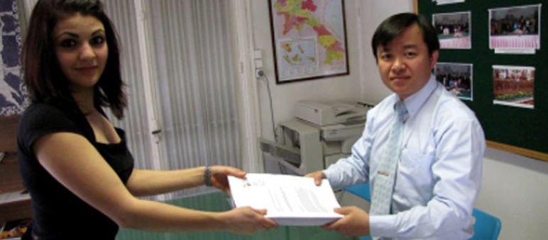 Our activist Nolwenn hands over the protest signatures to the prime secretary of the laotian consulate in Paris