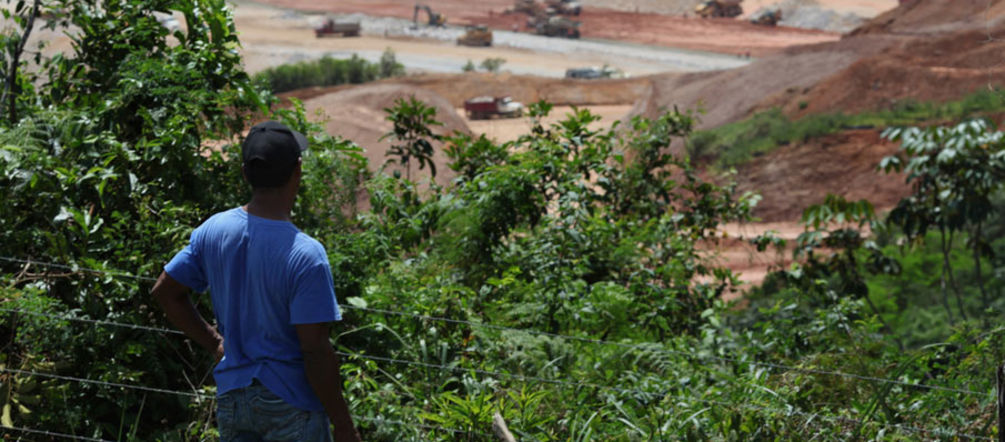 Speechless in the face of destruction A farmer standing in the forest, looking at an open-pit mine