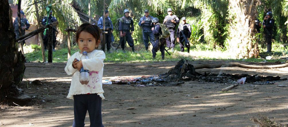 Peasant families in particular are suffering the terror of the palm oil industry. Photo: hondurasdelegation/flickr A frightened little girl in front of a group of paramilitaries