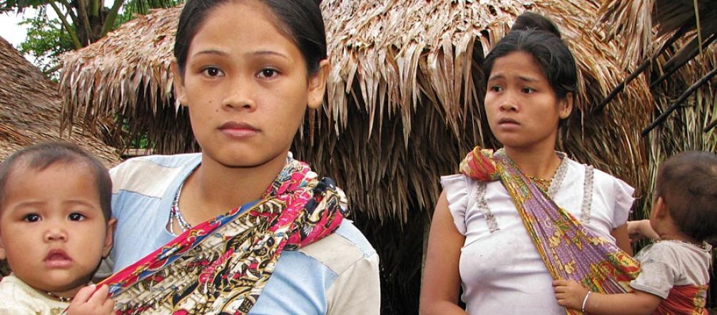 Two indigenous women with their children look worried