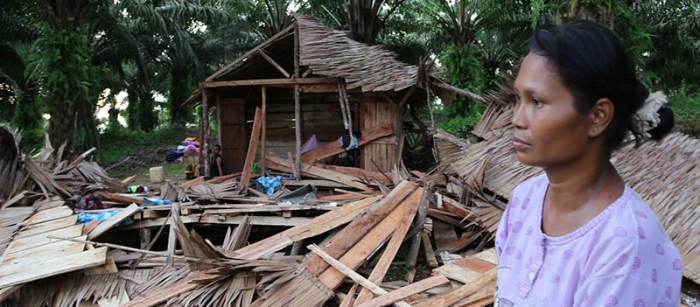 A shattered village community An indigenous woman stands in shock in front of her demolished house