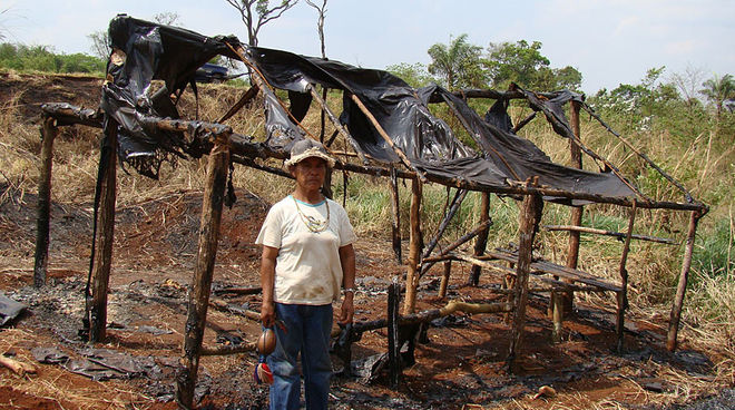 Damiana, a Guarani-Kaiowá and religious leader of Apyka'y commmunity, by a shack burned down during evictions