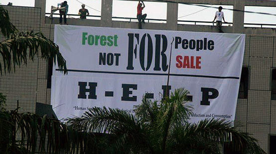 Protesters hanging up a banner: forest for people, not for sale