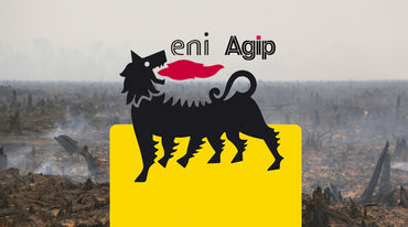 An Eni logo in front of the burning remains of a rainforest