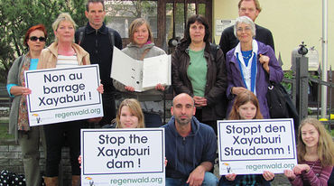 People infront of the embassy in Berlin holding protest signs against the dam