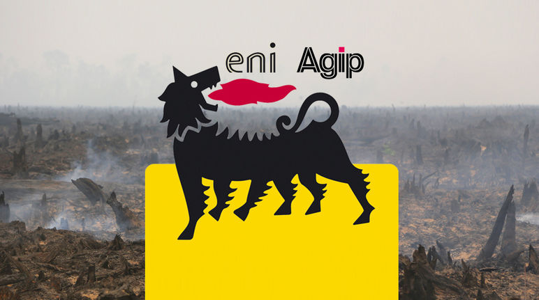 An Eni logo in front of the burning remains of a rainforest