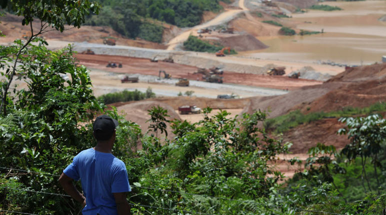 Speechless in the face of destruction A farmer standing in the forest, looking at an open-pit mine
