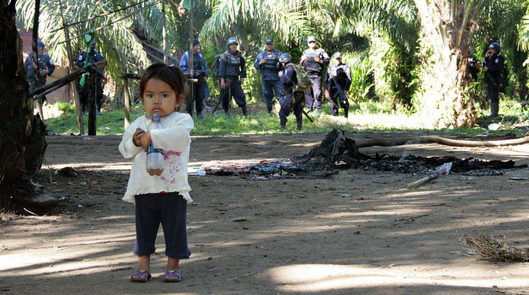 A frightened little girl in front of a group of paramilitaries