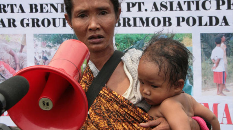 A woman carrying a child and a megaphone