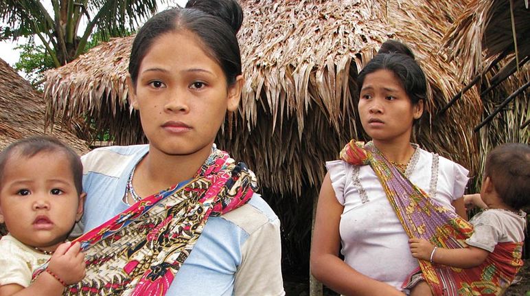 Two indigenous women with their children look worried