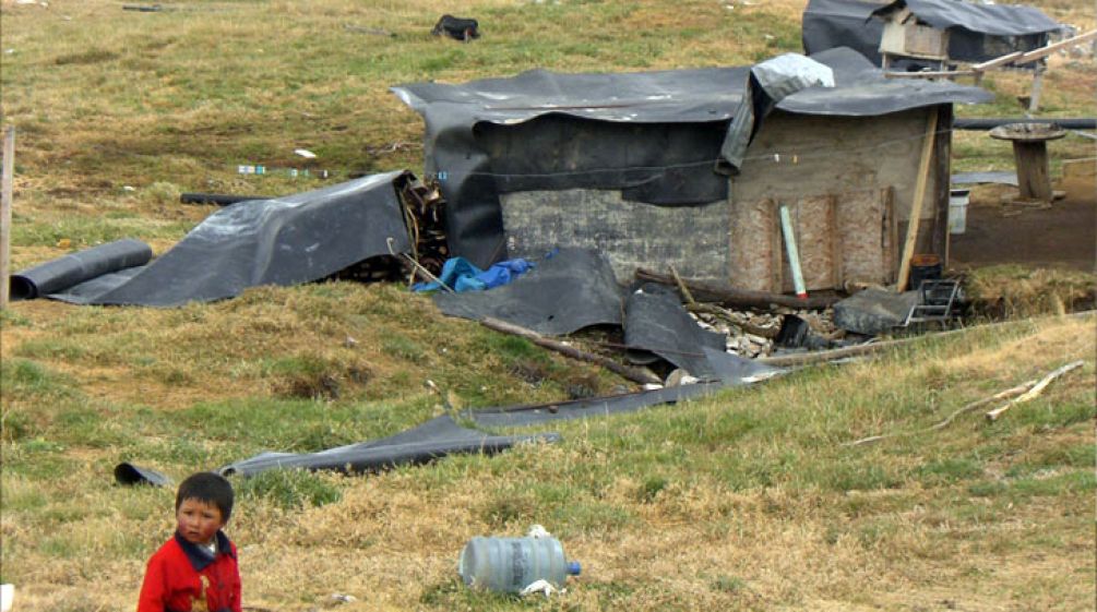 Cajamarcan infront of a fallen down hut