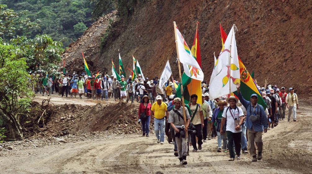 Indians on their protest march Indians on a protest march with flags in their hands walking up a gravel road